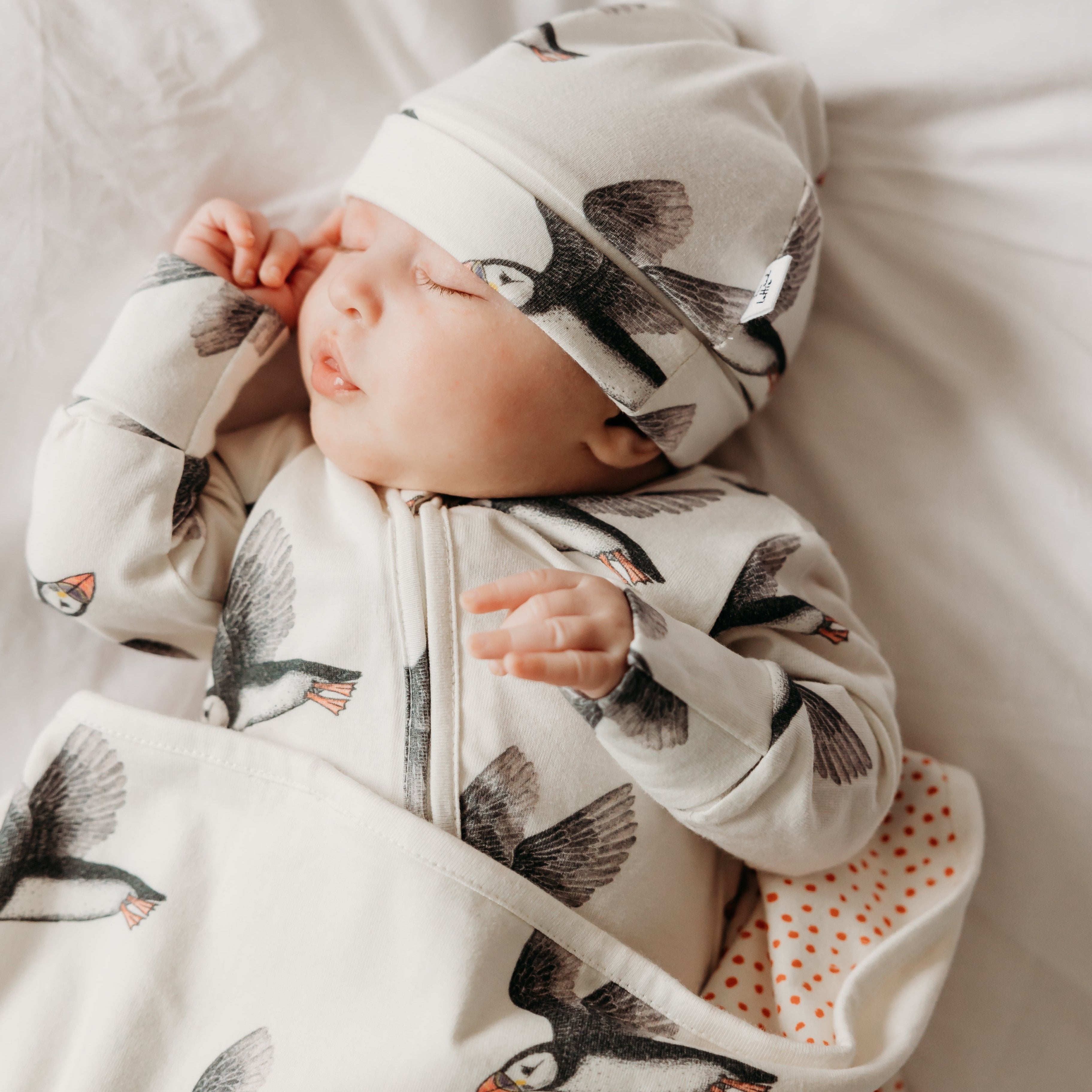 Baby in puffin hat, puffin sleepsuit and puffin blanket. Fox and Lottie premium children and baby sleepwear.