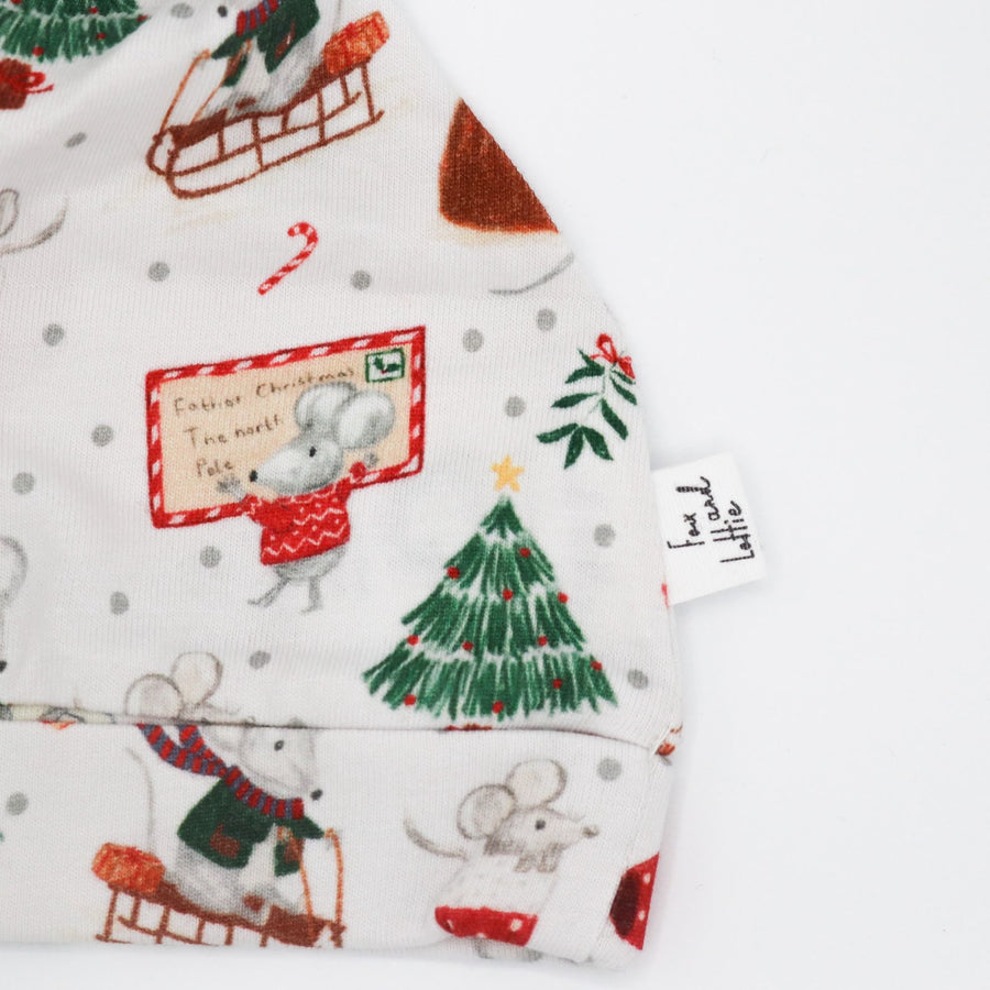 Christmas baby print hat from Fox and Lottie. Close up showing mouse with Christmas card and Christmas tree.