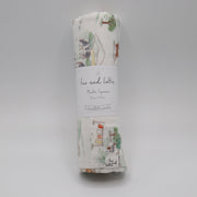 Rolled-up fabric swaddle with a label on a gray background, farm muslin