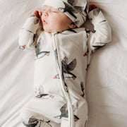 Baby sleeping in puffin sleepsuit and puffin hat